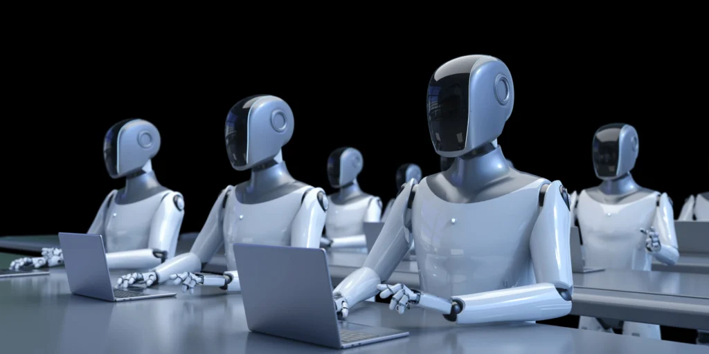 Multiple humanoid robots typing on laptops in an office setting.